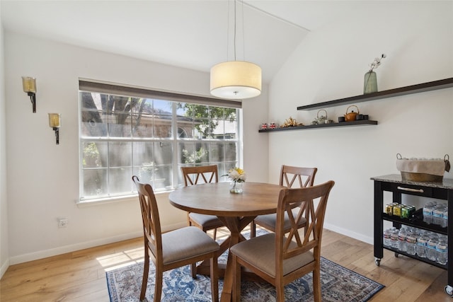 dining area with vaulted ceiling, a healthy amount of sunlight, and light hardwood / wood-style flooring