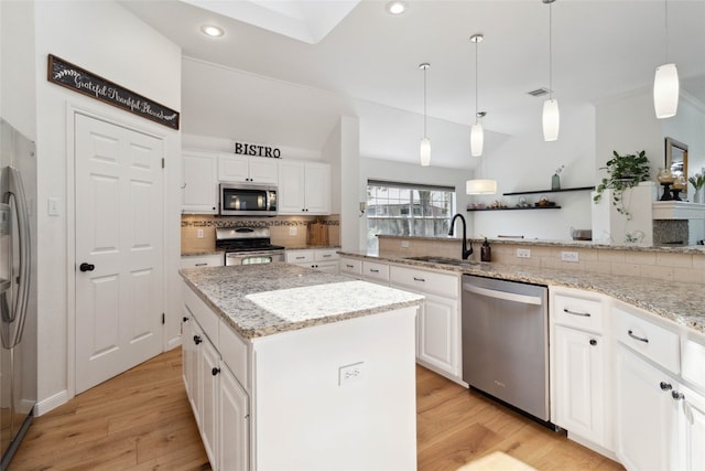 kitchen with a kitchen island, light wood-type flooring, appliances with stainless steel finishes, and white cabinets