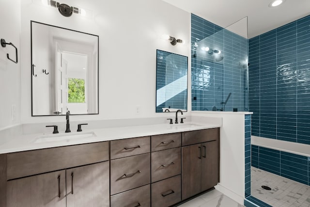 bathroom with tiled shower and vanity