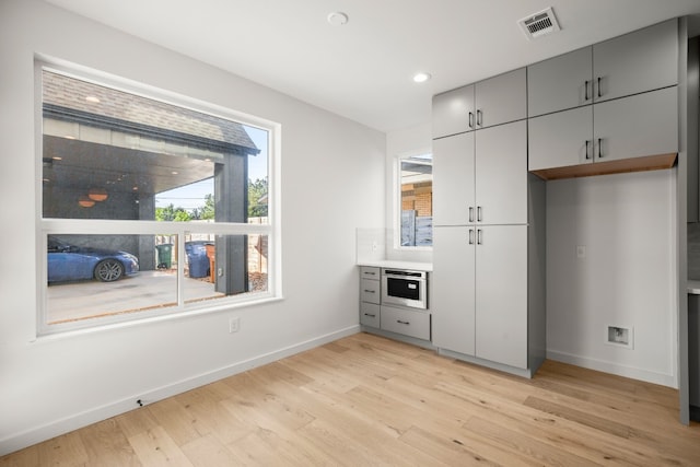 interior space featuring gray cabinetry and light hardwood / wood-style flooring