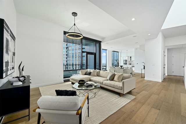 living room with expansive windows and light hardwood / wood-style floors