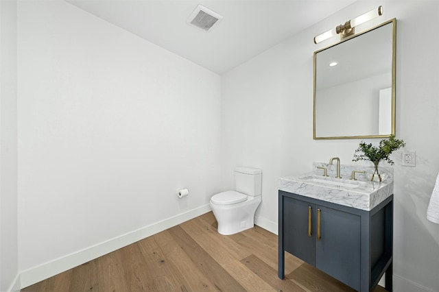 bathroom with vanity, hardwood / wood-style flooring, and toilet