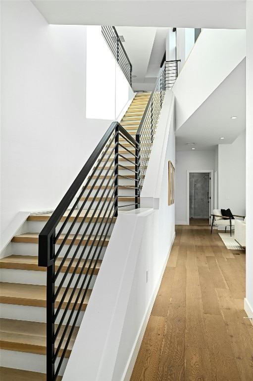 staircase featuring hardwood / wood-style flooring and a towering ceiling