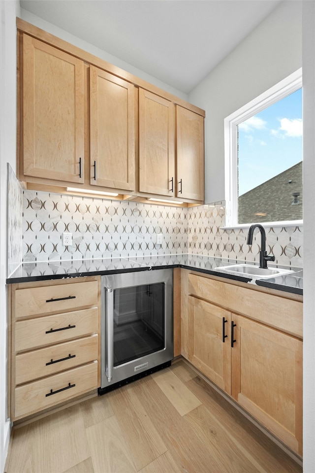 kitchen with tasteful backsplash, sink, beverage cooler, light hardwood / wood-style floors, and light brown cabinets