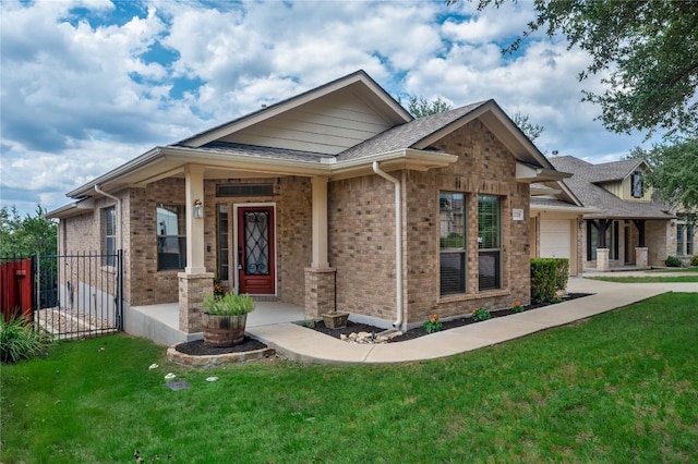 view of front of home featuring a garage, brick siding, and a front yard