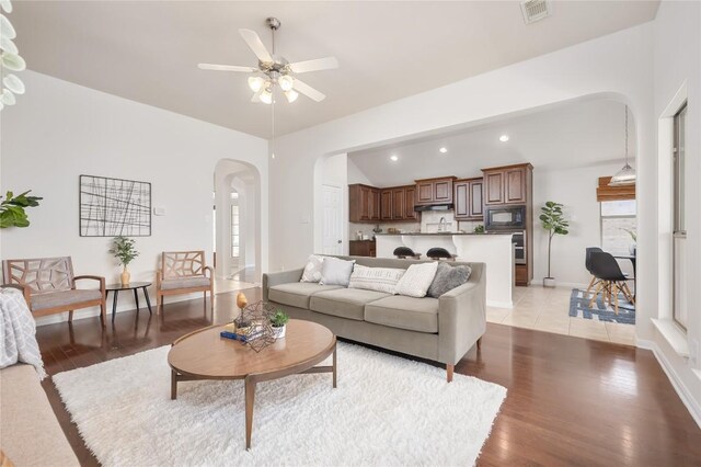 living room with light hardwood / wood-style floors, a wealth of natural light, and ceiling fan