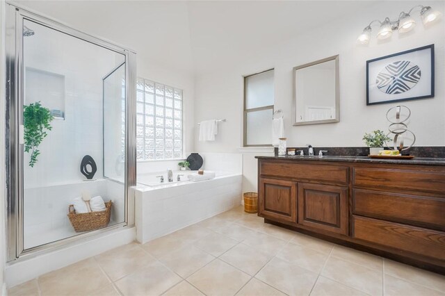 bathroom featuring plus walk in shower, vanity, and tile patterned flooring