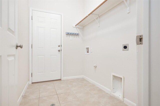 laundry area with hookup for an electric dryer, washer hookup, hookup for a gas dryer, and light tile patterned floors