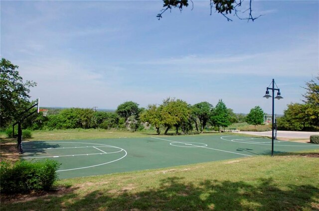 view of basketball court with a lawn