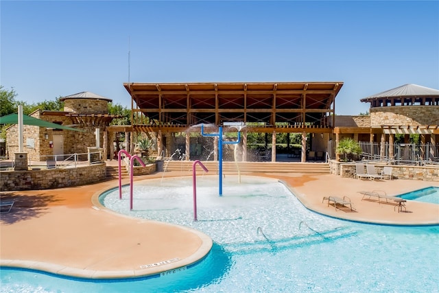 view of pool featuring pool water feature and a patio