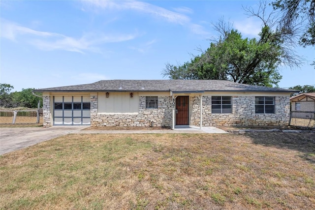 307 Golden Beach Dr, Buchanan Dam, TX 78609 - ranch-style house featuring stone siding, a front yard, concrete driveway, and an attached garage