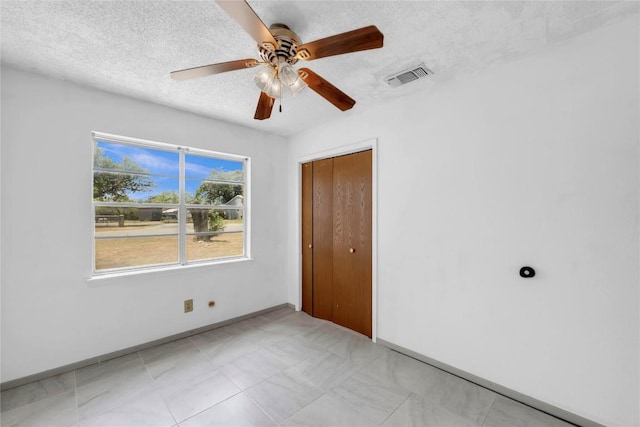 307 Golden Beach Dr, Buchanan Dam, TX 78609 - unfurnished bedroom featuring a ceiling fan, baseboards, visible vents, a closet, and a textured ceiling