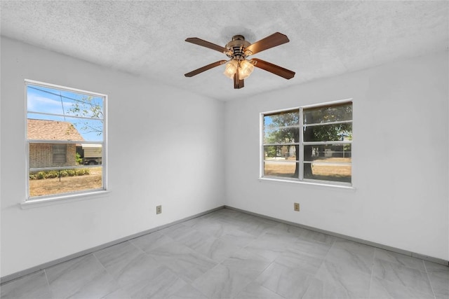 307 Golden Beach Dr, Buchanan Dam, TX 78609 - spare room with baseboards, a textured ceiling, and a ceiling fan
