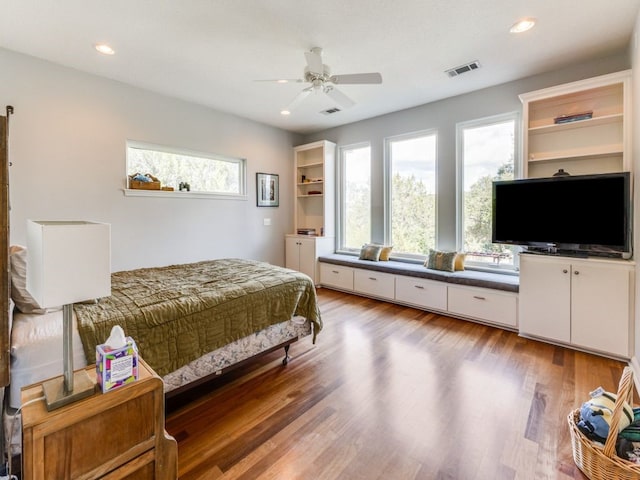 bedroom featuring multiple windows, hardwood / wood-style floors, and ceiling fan