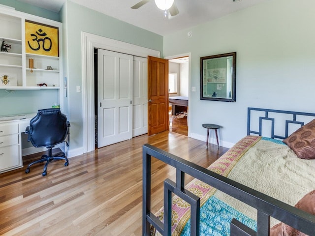 bedroom with light hardwood / wood-style flooring, ceiling fan, and a closet