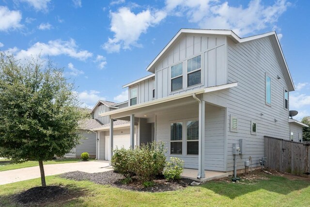 view of front facade featuring a garage, a porch, and a front lawn