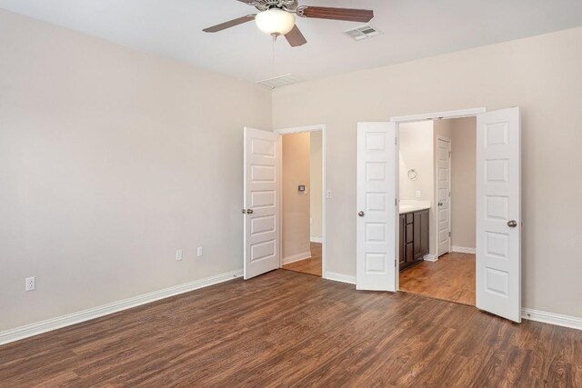 unfurnished bedroom with ceiling fan, dark hardwood / wood-style floors, and ensuite bathroom