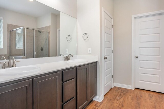 bathroom with walk in shower, hardwood / wood-style flooring, and vanity