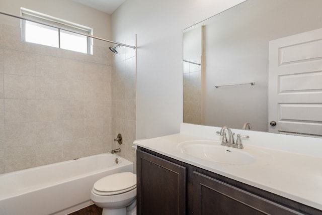 full bathroom with tiled shower / bath, toilet, and vanity