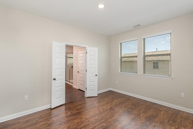 unfurnished bedroom with dark wood-type flooring