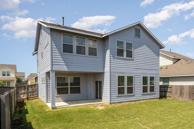 rear view of property with a lawn and a patio