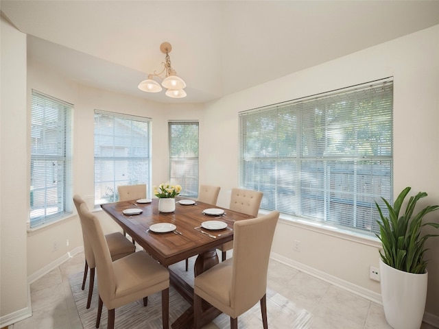 tiled dining area with an inviting chandelier and a healthy amount of sunlight