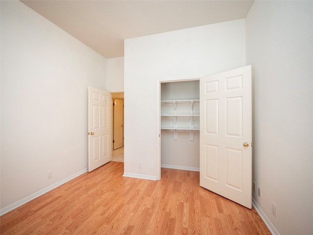 unfurnished bedroom with light wood-type flooring and a closet