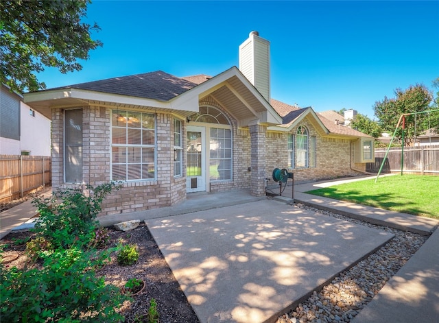 view of front of home featuring a front yard and a patio