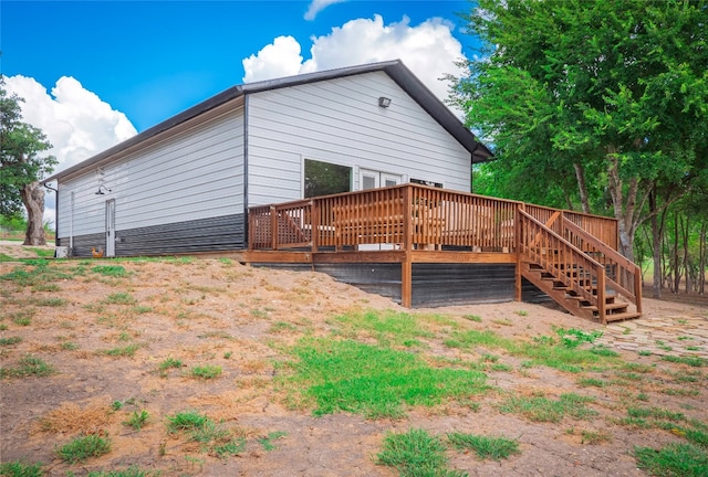 rear view of property featuring a wooden deck