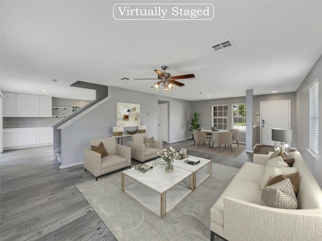 living room featuring light wood-type flooring and ceiling fan