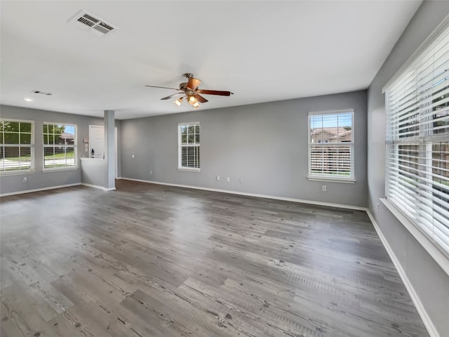 unfurnished living room featuring hardwood / wood-style floors, ceiling fan, and a healthy amount of sunlight