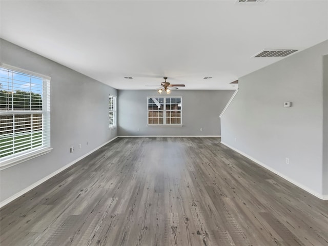 unfurnished living room featuring ceiling fan and dark hardwood / wood-style flooring