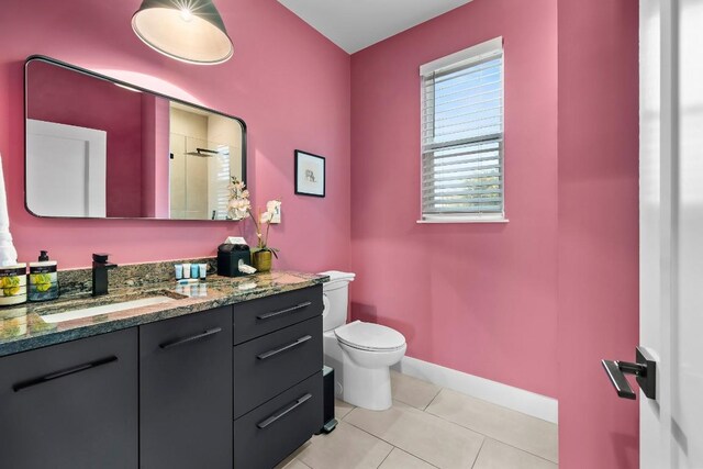 6217 Clovis St Unit B, Austin, TX 78741 - bathroom with toilet, vanity, tile patterned flooring, baseboards, and a shower