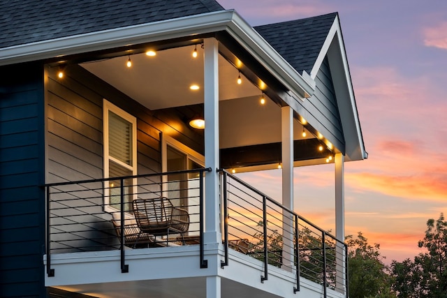 property exterior at dusk featuring a balcony