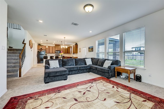 living room with light colored carpet and a chandelier