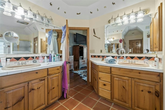 full bathroom featuring backsplash, two vanities, and a sink