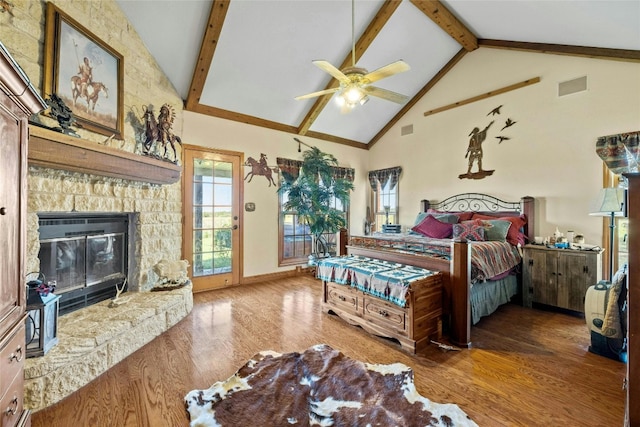 bedroom featuring access to exterior, beamed ceiling, a stone fireplace, wood finished floors, and high vaulted ceiling