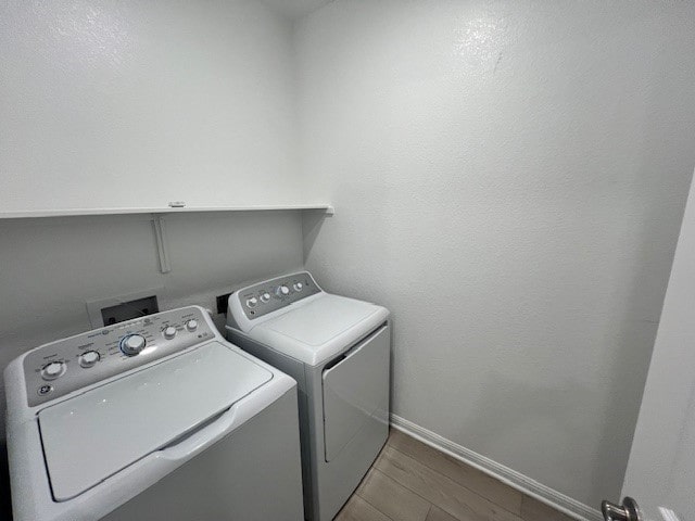 washroom with wood-type flooring and washing machine and clothes dryer