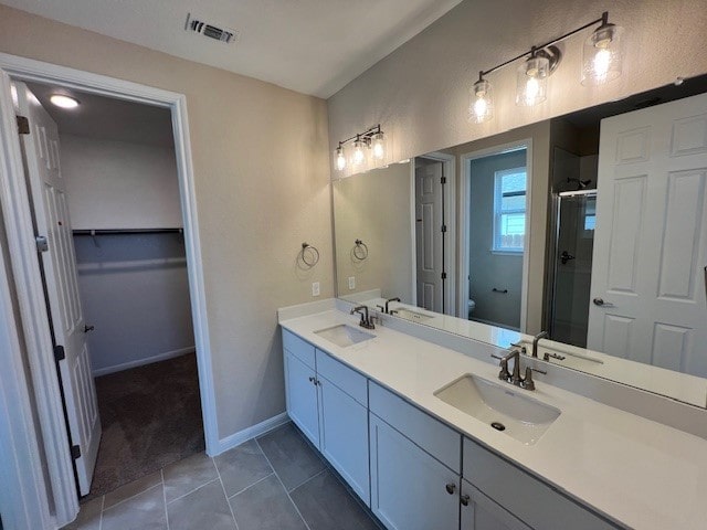 bathroom featuring tile patterned flooring, vanity, toilet, and an enclosed shower