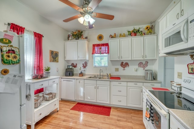 kitchen featuring white appliances, ceiling fan, sink, white cabinets, and light hardwood / wood-style floors