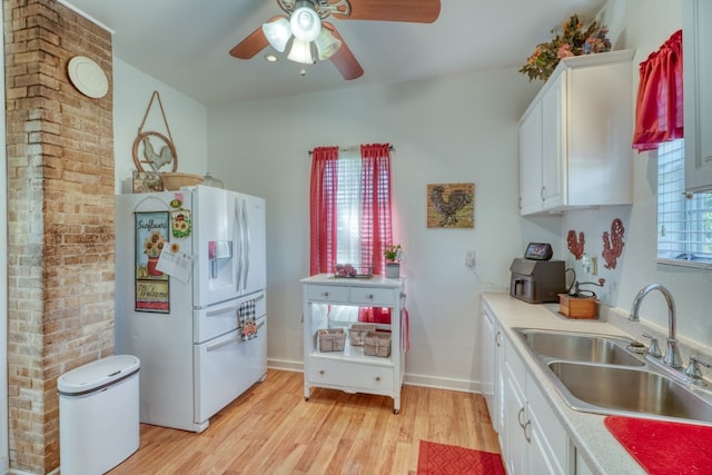 kitchen with white cabinetry, white refrigerator with ice dispenser, sink, and light hardwood / wood-style flooring