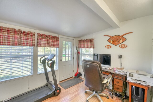 office space featuring vaulted ceiling with beams, light hardwood / wood-style floors, and a wealth of natural light