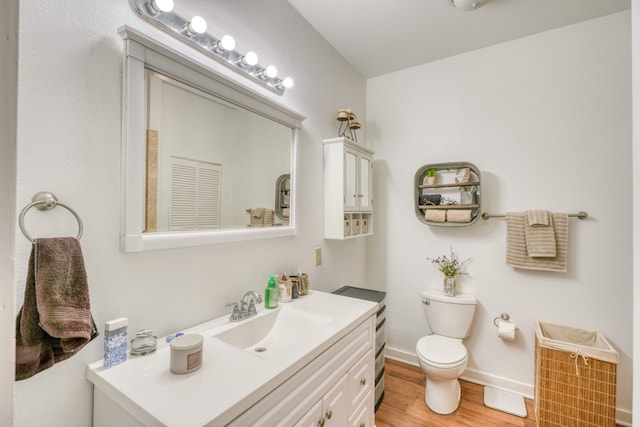 bathroom featuring hardwood / wood-style flooring, vanity, and toilet