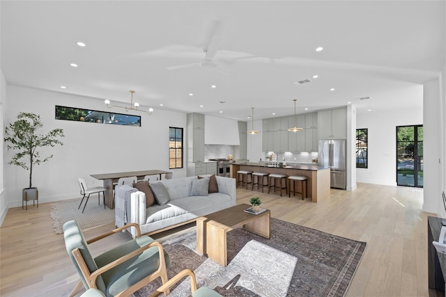 living room featuring light hardwood / wood-style flooring and ceiling fan