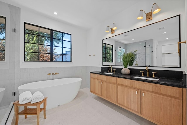 bathroom with plenty of natural light, vanity, and tile walls