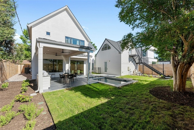 rear view of property with central AC unit, ceiling fan, a patio, and a lawn