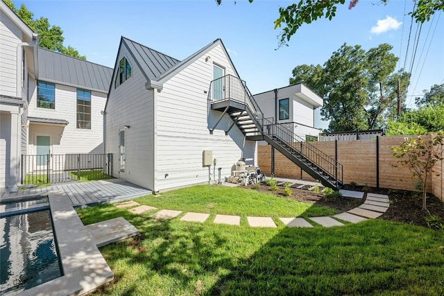 rear view of house featuring a yard, a balcony, and a patio