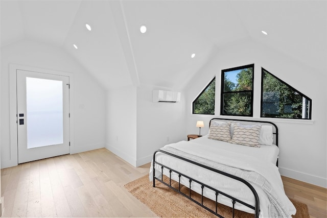 bedroom with light wood-type flooring, vaulted ceiling, and a wall unit AC