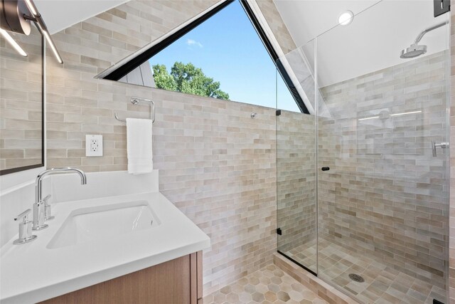 bathroom featuring tile patterned floors, vanity, an enclosed shower, and tile walls