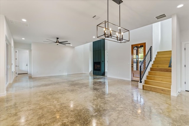 interior space featuring concrete floors and ceiling fan with notable chandelier